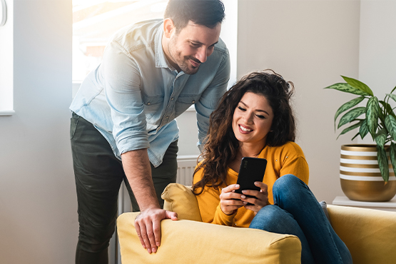 happy couple looking at phone and enjoying better checking with Gate City Bank