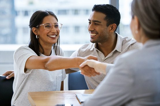 a happy couple chats with an advisor after learning about ways to cut home insurance costs from Gate City Insurance Agency