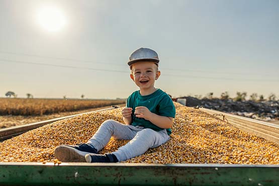 Happy boy in baseball cap, sitting in a grain truck on his family farm outside of Portland, ND