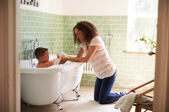 adoring mom giving her son a bubble bath in a new clawfoot tub, thanks to a home equity loan from Gate City Bank in ND