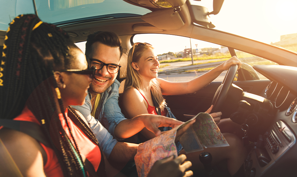 group of three young friends rides in a car together for a fun road trip