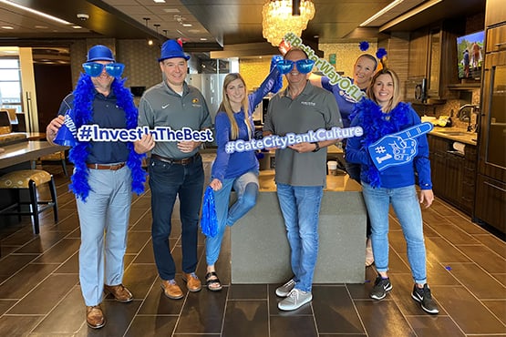 team members sporting goofy props pose for a photo while celebrating their culture