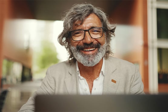 A happy male business owner gazes toward the camera after learning about common tax write-offs from Gate City Bank