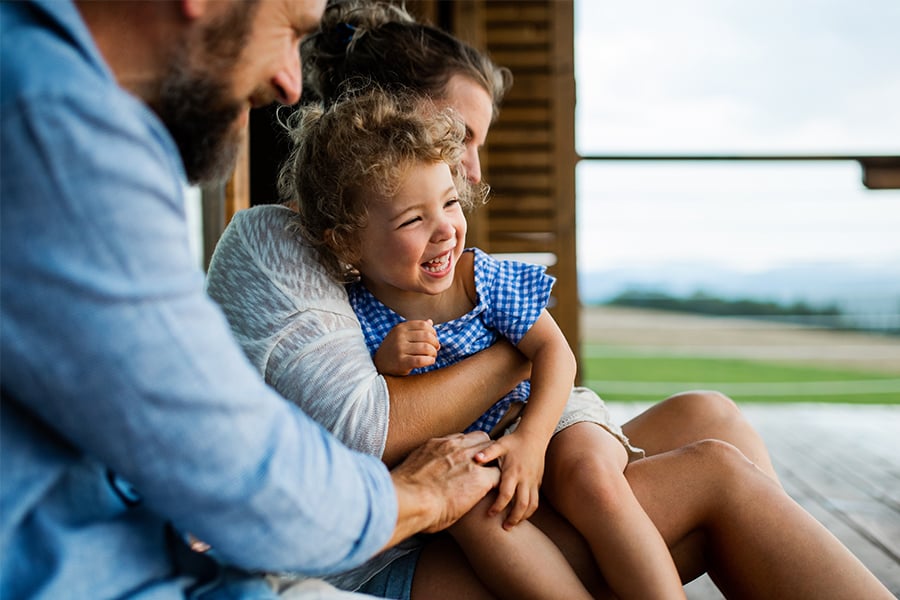 Happy young girl on the porch of her family’s new home, purchased with a Gate City Bank home loan in Fargo, ND