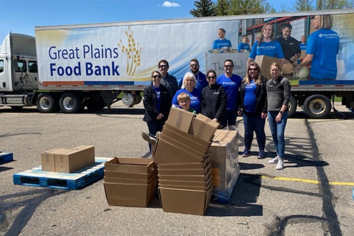 Minot Gate City Bank volunteers take photo in front of Great Plains Food Bank truck