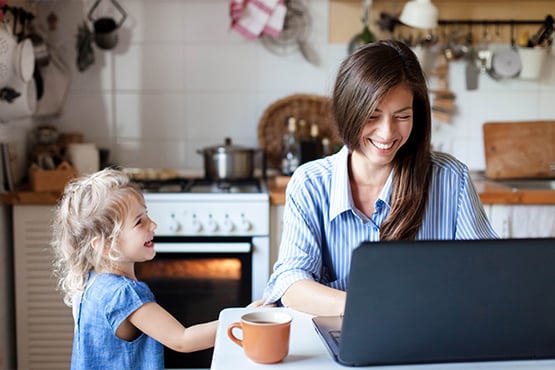 young mother and daughter at kitchen table enjoy business checking accounts on laptop