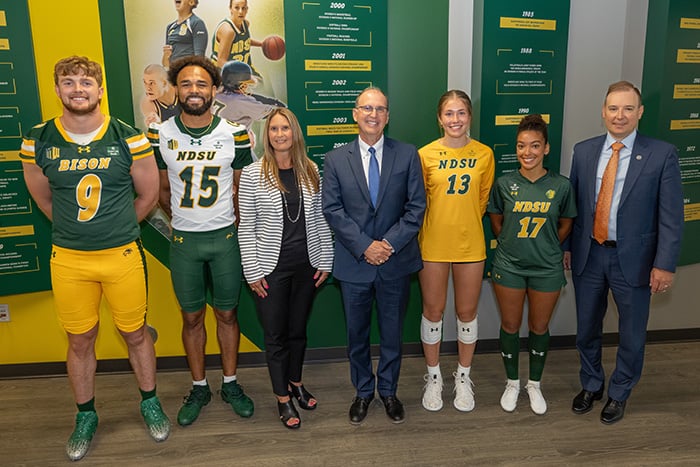 Members of Gate City Bank’s executive leadership team pose with NDSU Bison student athletes wearing jerseys with the bank’s logo, announcing the bank as the first all-sport jersey patch partner of NDSU Athletics.