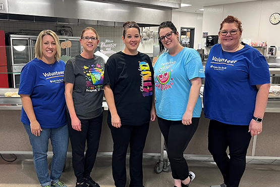 Gate City Bank volunteers Michelle Neumiller and Jacque Erickson pose with some of the Jamestown Middle School lunch staff