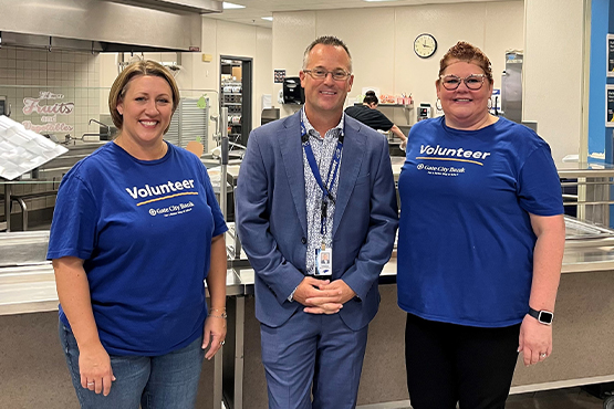 Gate City Bank volunteers Michelle Neumiller and Jacque Erickson smile with Jamestown Middle School Principal Mark Stilwell