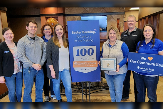 Gate City Bank team members at their Jamestown, ND, location huddle for a picture around the bank’s 100<sup>th</sup> anniversary logo