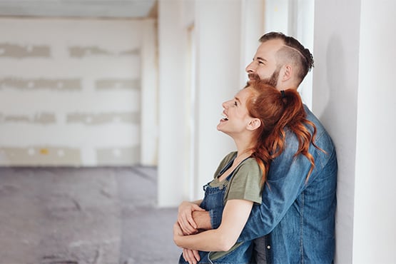 couple happy about home improvement loan observes updates and embraces each other 