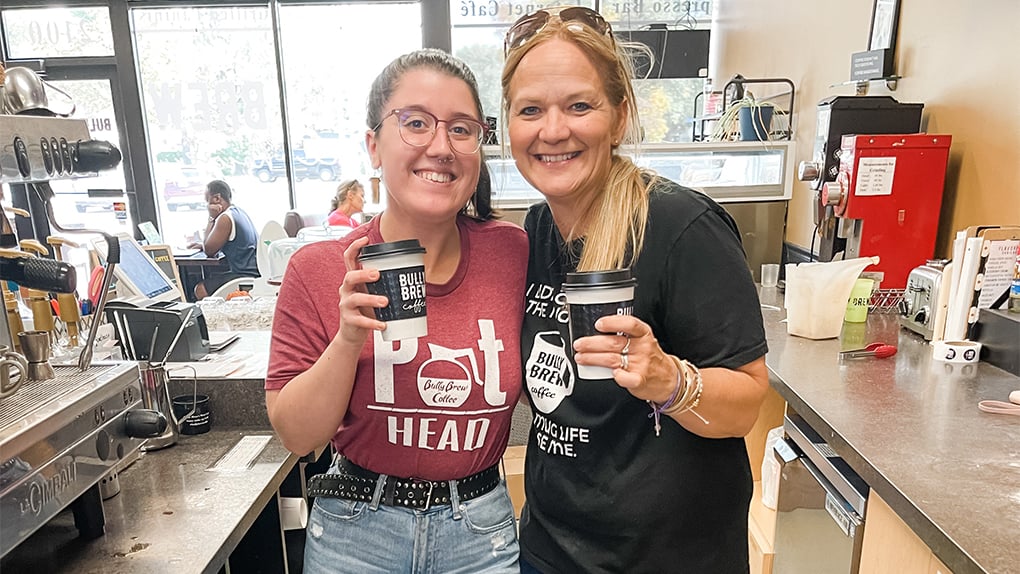 Two Bully Brew Coffee staffers hold coffee and pose for a picture
