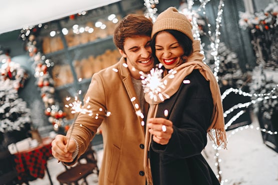 young couple enjoys celebrating healthy financial habits during the new year with sparklers