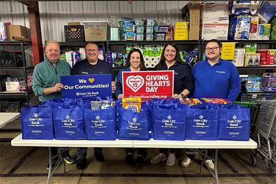 Gate City Bank employees deliver blue bags of donated nonperishable items to a food pantry.