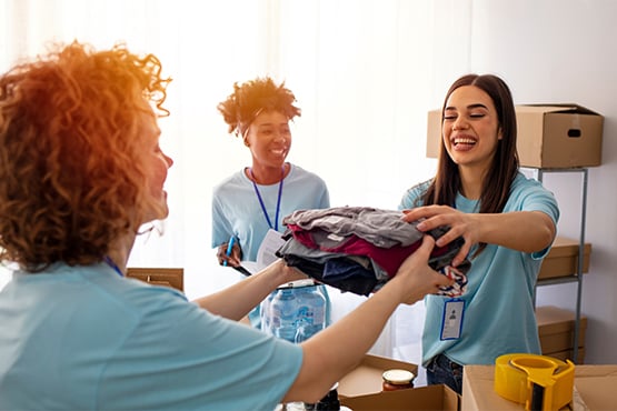 charity volunteers handle donated clothes after signing up for nonprofit interest checking
