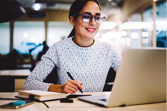 young woman with glasses studies security and fraud protection on laptop