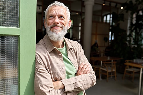 Smiling senior standing outside a café in Fargo, ND, on his way to his nearest Gate City Bank location 