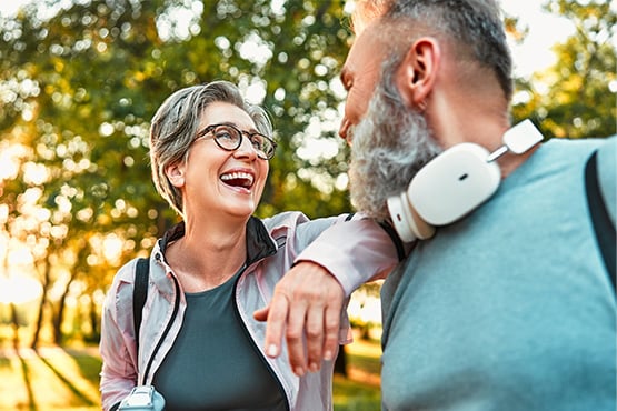 A man and woman smile at each other in the park after better understanding Medicare thanks to Gate City Insurance Agency
