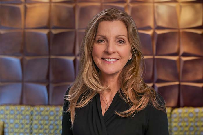a professional headshot of retired Gate City Bank executive Kim Meyer smiling at the camera while wearing black
