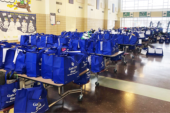 dozens of Gate City Bank blue bags hold student home learning materials at local school