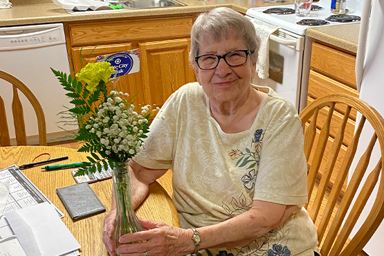 joyful assisted living residents accept flowers from Gate City Bank team members