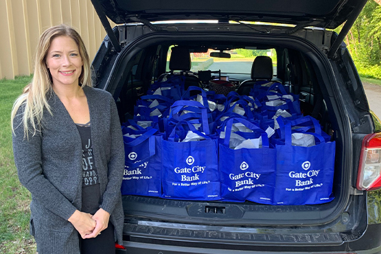 Gate City Bank blue tote bags are delivered in a vehicle and donated to first responders