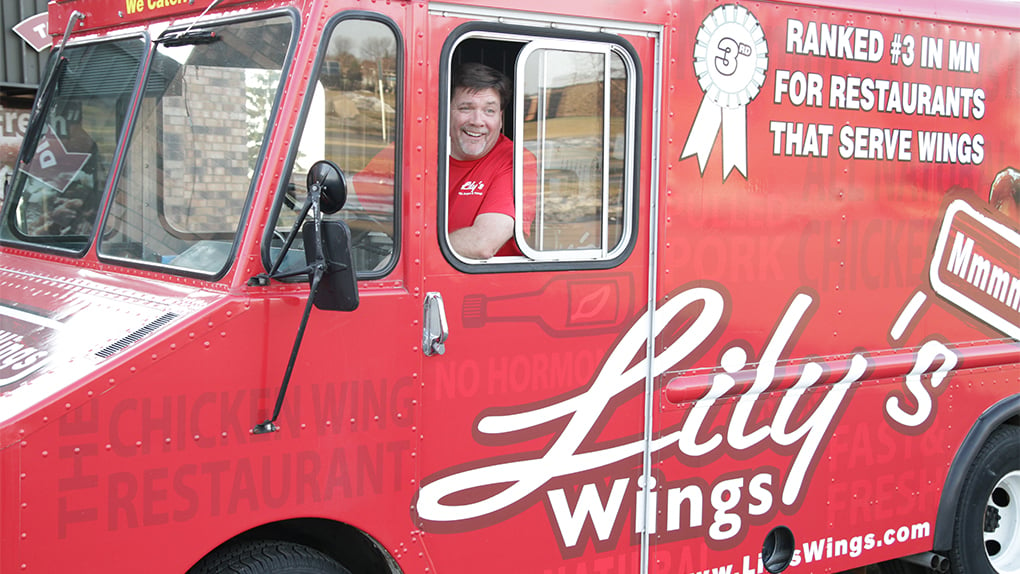 Lily's: Steve Ehlen co-owner of Lily’s Wings Burgers and Things smiles at wheel of food truck