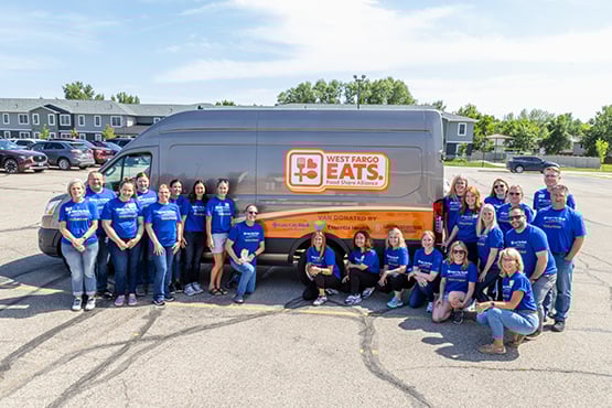Gate City Bank team members surround the West Fargo Eats van after distributing meals to community members in need.