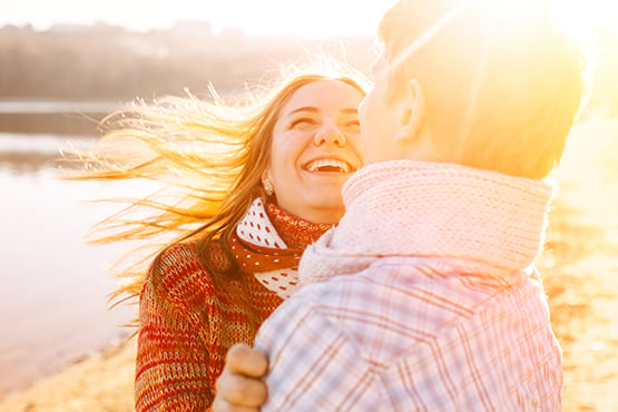 couple smiles together on sunny day near lake after experiencing Gate City Bank benefits