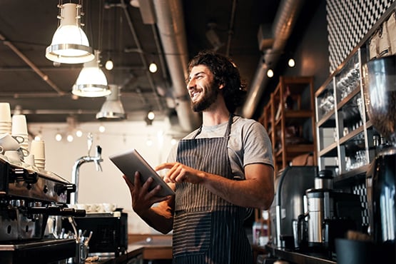 male business owner crosses arms and smiles while enjoying better business banking