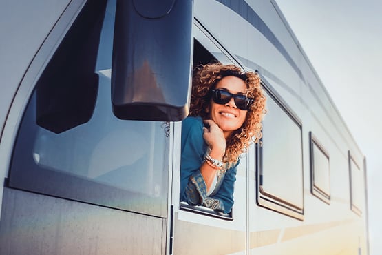 smiling woman looking at the horizon from her new RV