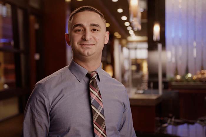 Lezan Tahir smiles in a shirt and tie from Gate City Bank’s location in downtown Fargo, ND