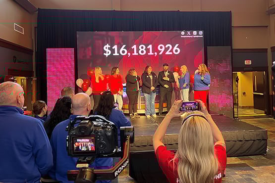 Rape and Abuse Crisis Center representatives react with excitement onstage as Gate City Bank team members and others look on