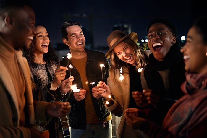 Group of friends laughing in downtown Fargo, ND, holding sparklers to celebrate opening their new Gate City Bank checking accounts