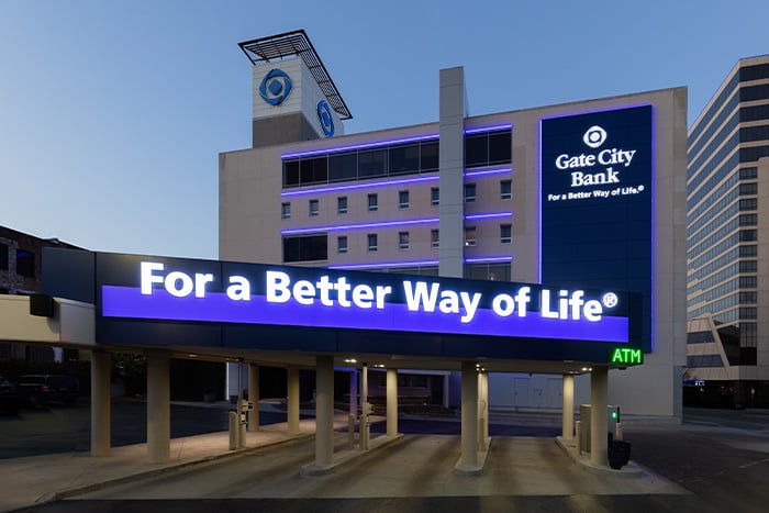Gate City Bank downtown Fargo location with the For a Better Way of Life sign lit against the dusk sky.