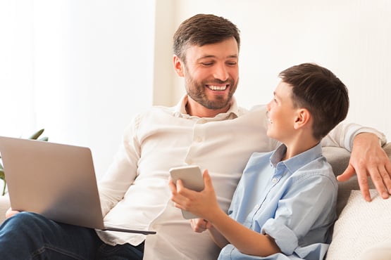 father and young son sit together and open the best savings account for kids
