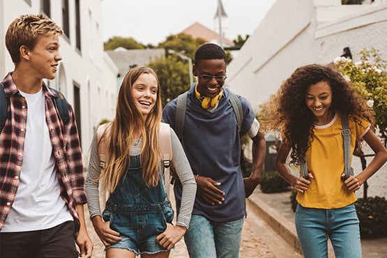 Four teens walking home from Gate City Bank’s Fargo downtown location after opening student bank accounts after school