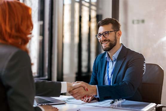 Smiling small business owner in a blue blazer, talking with his retirement plan advisor at Gate City Investment Services