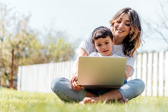 mother and young child look at a computer to follow Gate City Bank tips on how to stay protected from fraudster criminals