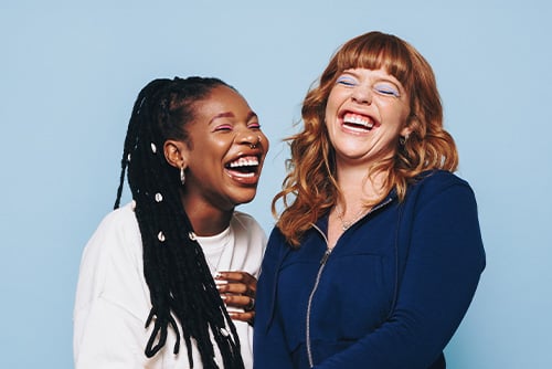 Two girls laughing together after referring friends to open a checking account at Gate City Bank in Bismarck, North Dakota