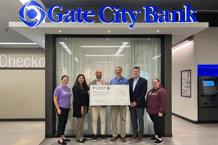 Ryan Coye, SVP of Central Minnesota, holds a big check for $40,000 beside leaders from Anna Marie’s Alliance in St. Cloud, MN
