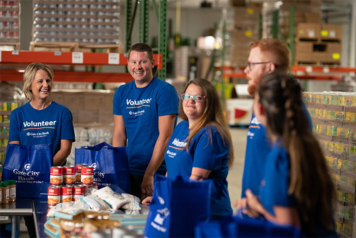 Joyful Gate City Bank team members volunteer for a local food pantry b sorting donated items