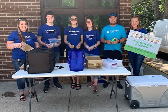 Gate City Bank team members and Mickey Munson at St. Joseph’s Social Services pose for a picture for the summer lunch program