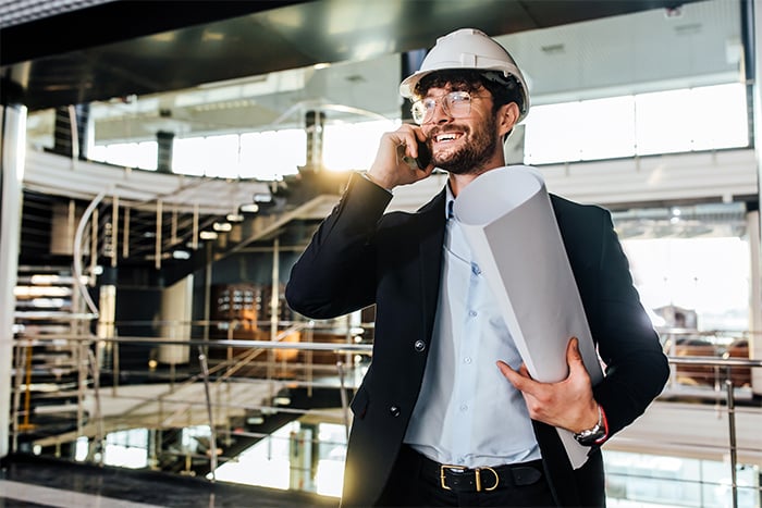 happy industrial businessman holds phone and paper after securing business term loans