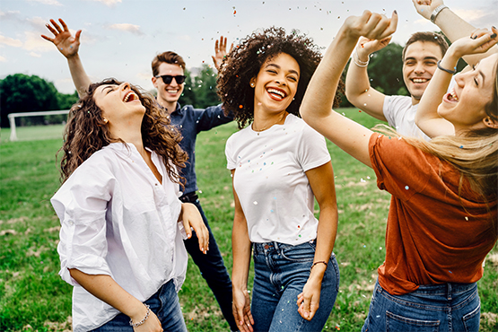 laughing group of young people dance in the park on a sunny day and celebrate special offers from gate city bank