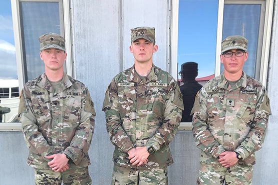 Bleau Hoge and two fellow service members gather before a building and pose for a picture while in uniform