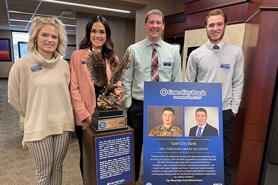 Four of Bleau Hoge’s fellow Bismarck, ND-based team members pose with an award the bank received for military support