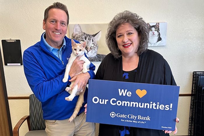 A Gate City Bank employee gives a donation to Cat’s Cradle Shelter through the bank’s charity gift program for homebuyers