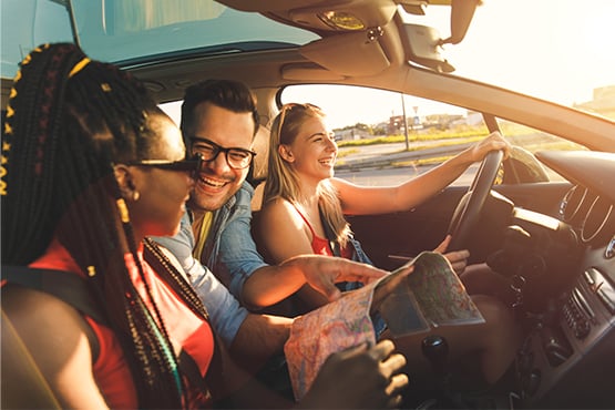 Three happy friends in Fargo, ND, heading out for a road trip thanks to an easy auto loan with Gate City Bank