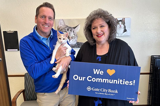A Gate City Bank employee gives a donation to Cat&rsquo;s Cradle Shelter through the bank&rsquo;s charity gift program for homebuyers